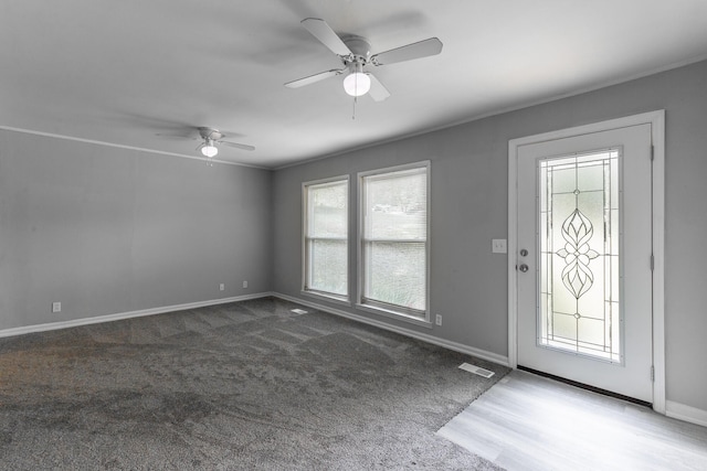 carpeted entryway with baseboards and ceiling fan