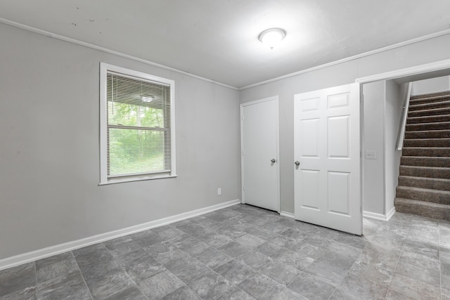 unfurnished bedroom featuring crown molding, baseboards, and a closet