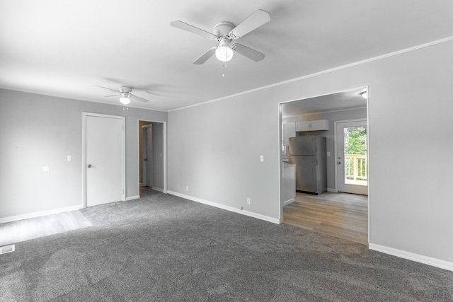 carpeted empty room featuring ceiling fan, baseboards, and crown molding