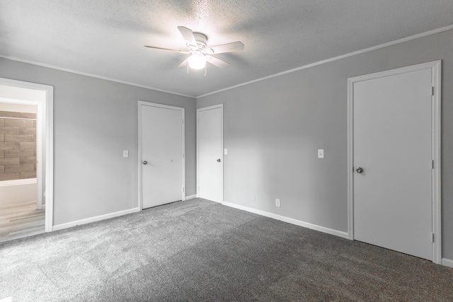 unfurnished bedroom featuring a textured ceiling, carpet, crown molding, connected bathroom, and baseboards