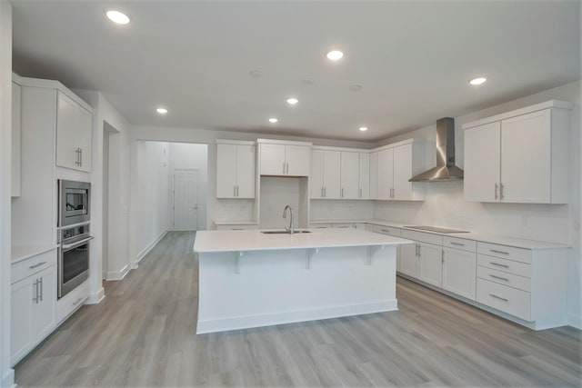 113 W Cassa Way, Mount Juliet, TN 37122 - kitchen featuring wall chimney exhaust hood, stainless steel appliances, a sink, light wood-style floors, and decorative backsplash