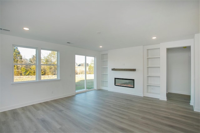 113 W Cassa Way, Mount Juliet, TN 37122 - unfurnished living room with wood finished floors, a glass covered fireplace, built in features, baseboards, and recessed lighting