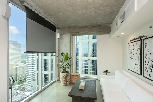 living room featuring concrete floors, a barn door, expansive windows, and a view of city