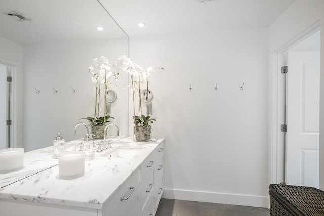 bathroom featuring baseboards, vanity, and recessed lighting