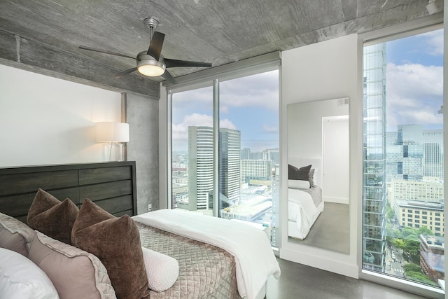 bedroom featuring a city view, ceiling fan, and concrete flooring