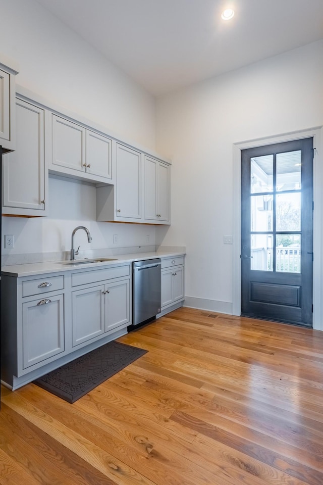 504 Doubleday Ln, Brentwood, TN 37027 - kitchen with stainless steel dishwasher, a sink, light countertops, light wood-type flooring, and gray cabinetry