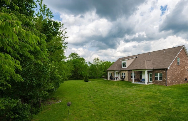 view of green lawn with a patio area