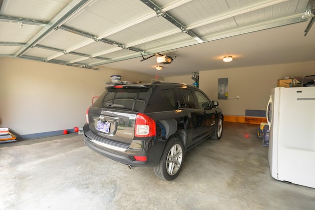 garage with freestanding refrigerator, a garage door opener, baseboards, and electric panel