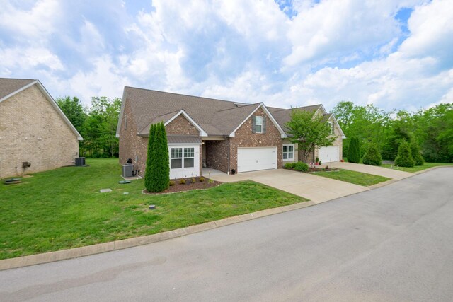 traditional home with driveway, central AC unit, a front yard, and brick siding