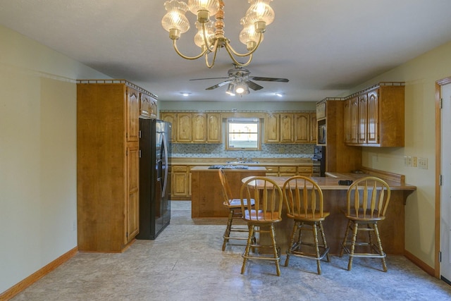 311 Locust St, Alexandria, TN 37012 - kitchen with black appliances, a peninsula, a sink, and brown cabinetry