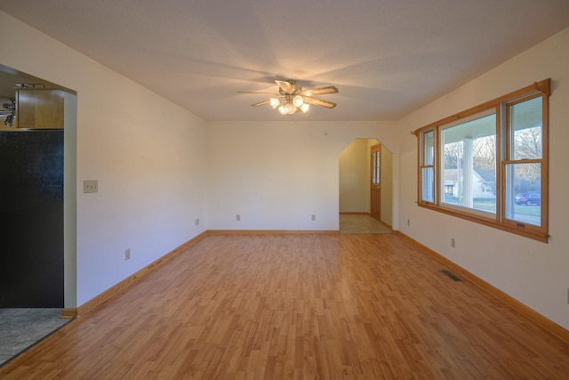311 Locust St, Alexandria, TN 37012 - unfurnished living room with light wood finished floors, a ceiling fan, baseboards, and arched walkways