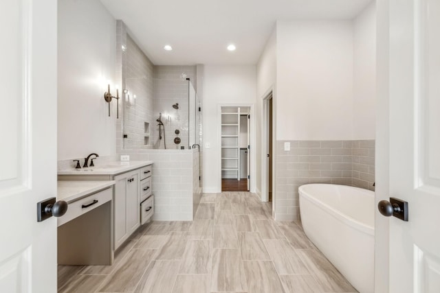 1900 Martha Washington Way, Murfreesboro, TN 37130 - bathroom featuring a stall shower, a walk in closet, vanity, tile walls, and a freestanding bath