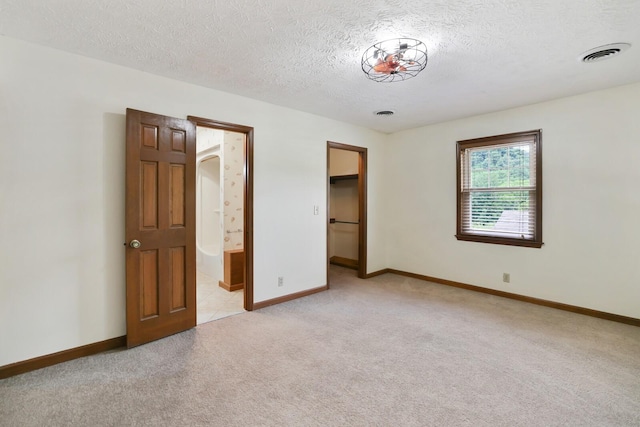 1361 Madison Creek Rd, Goodlettsville, TN 37072 - unfurnished bedroom with light carpet, a textured ceiling, a walk in closet, and ensuite bathroom