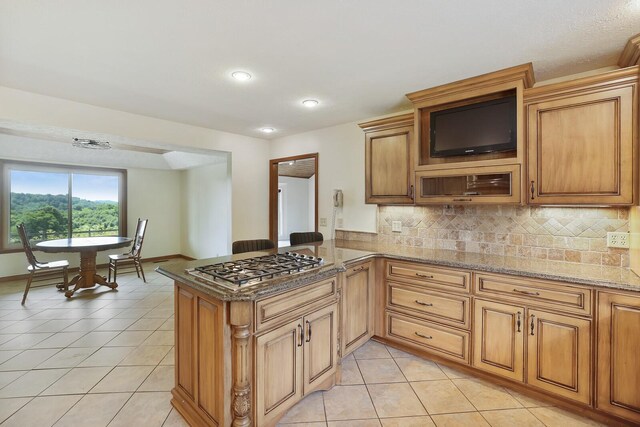 1361 Madison Creek Rd, Goodlettsville, TN 37072 - kitchen with stainless steel gas stovetop, light tile patterned floors, a peninsula, light stone counters, and tasteful backsplash