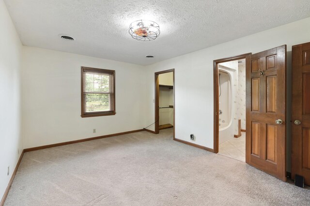 1361 Madison Creek Rd, Goodlettsville, TN 37072 - unfurnished bedroom with light carpet, a textured ceiling, ensuite bath, and a spacious closet