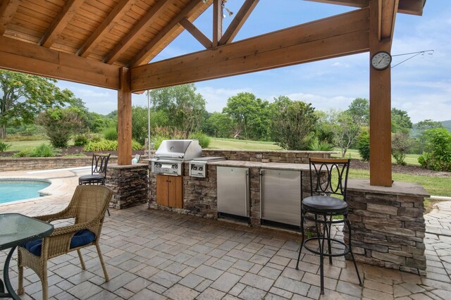 1361 Madison Creek Rd, Goodlettsville, TN 37072 - view of patio featuring area for grilling, a gazebo, exterior bar, view of wooded area, and an outdoor pool