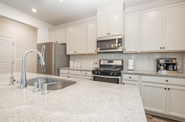 1063 Holland Ridge Way, Lebanon, TN 37090 - kitchen with appliances with stainless steel finishes, a sink, tasteful backsplash, white cabinetry, and recessed lighting