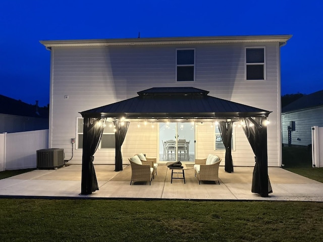 1063 Holland Ridge Way, Lebanon, TN 37090 - back of house at night featuring a gazebo, metal roof, a patio, a standing seam roof, and an outdoor hangout area