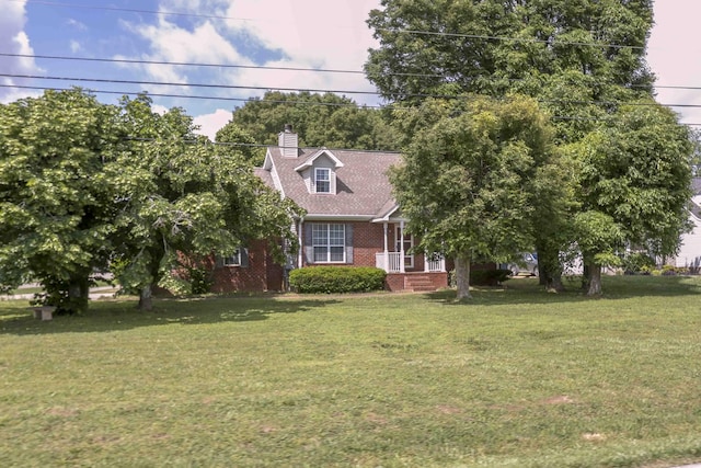 cape cod home with a front lawn, brick siding, and a chimney
