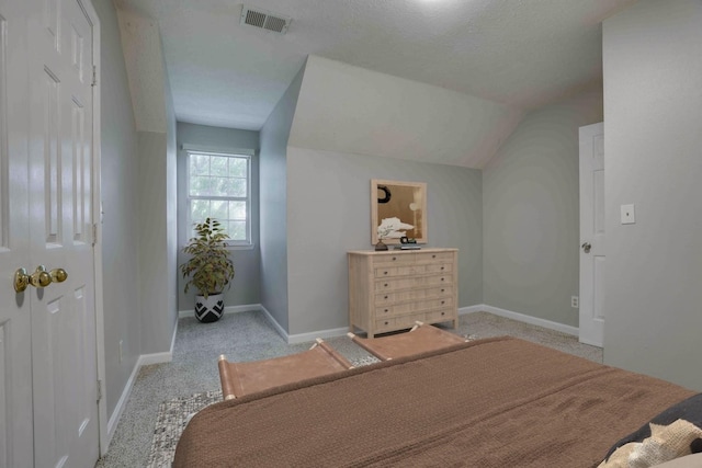 bedroom featuring light colored carpet, baseboards, and vaulted ceiling