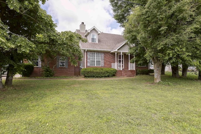 view of front of property featuring brick siding, a front yard, and a chimney