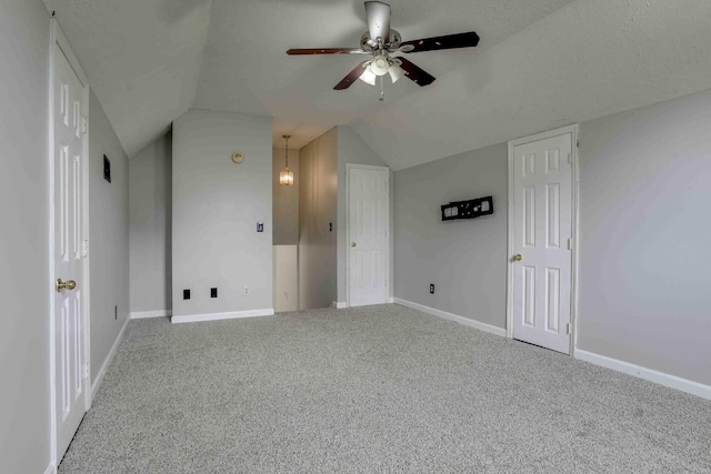 additional living space featuring a ceiling fan, lofted ceiling, carpet, and baseboards
