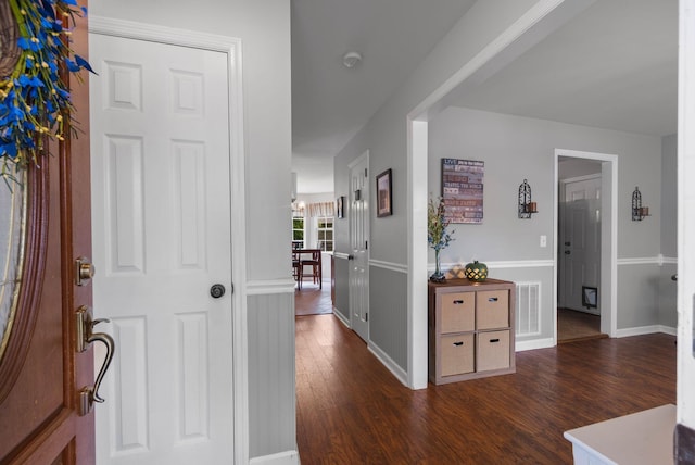 foyer with dark wood finished floors and baseboards