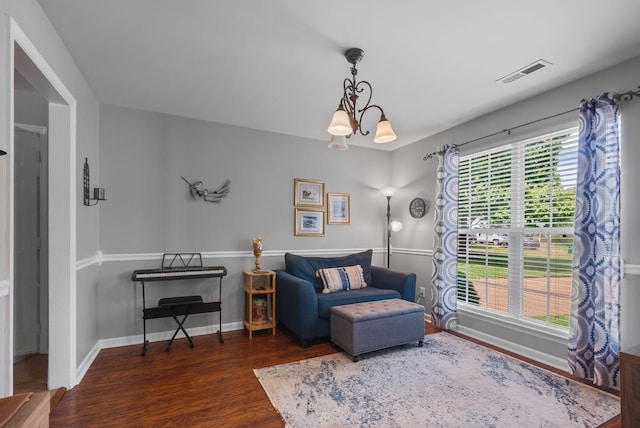 sitting room with wood finished floors, a chandelier, and baseboards