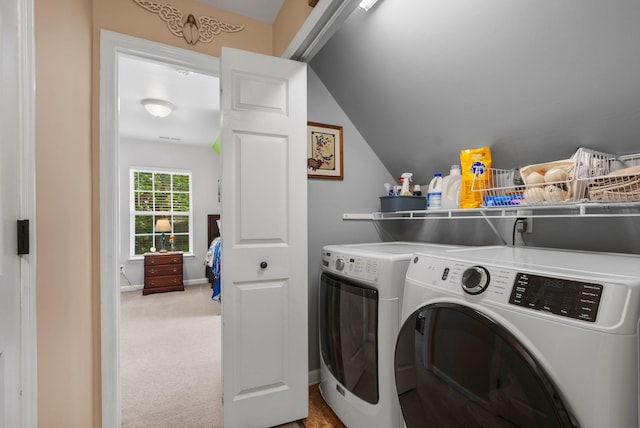 washroom featuring washer and clothes dryer and light colored carpet