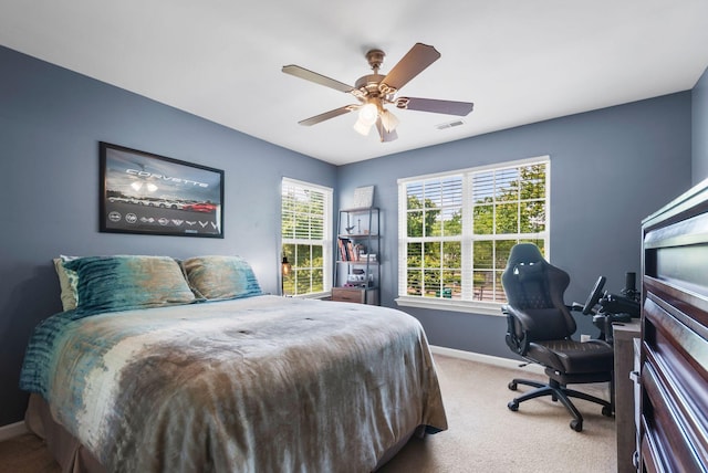 carpeted bedroom featuring baseboards, a desk, and a ceiling fan