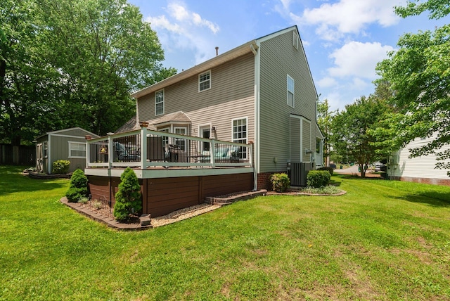 rear view of house featuring a deck, central AC unit, a shed, an outdoor structure, and a lawn