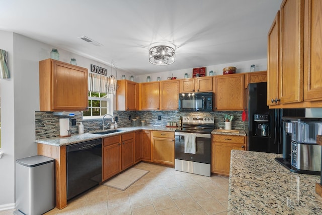 kitchen featuring black appliances, a sink, tasteful backsplash, and light stone counters