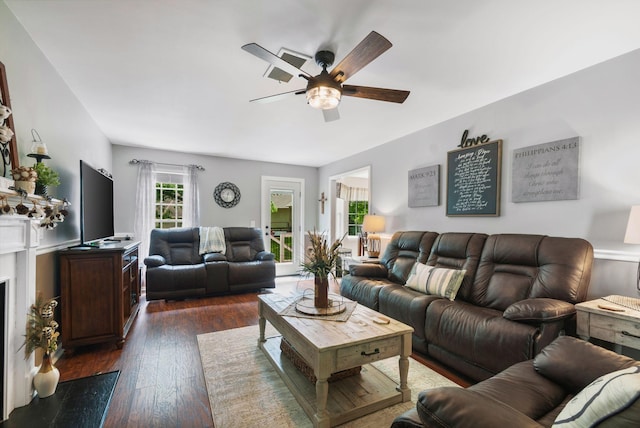 living room featuring a ceiling fan and dark wood-type flooring