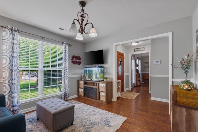 living room with a chandelier, wood finished floors, and baseboards