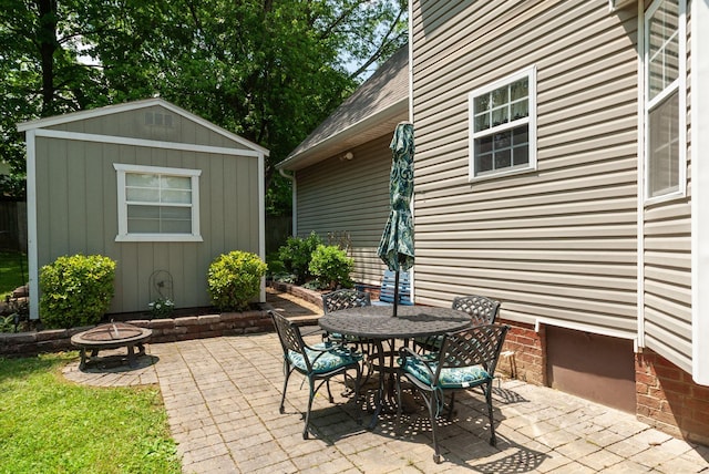 view of patio / terrace featuring a fire pit, an outdoor structure, and outdoor dining area