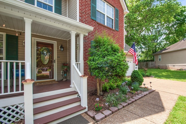 view of exterior entry featuring brick siding and covered porch