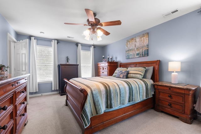 bedroom with light colored carpet, baseboards, and a ceiling fan