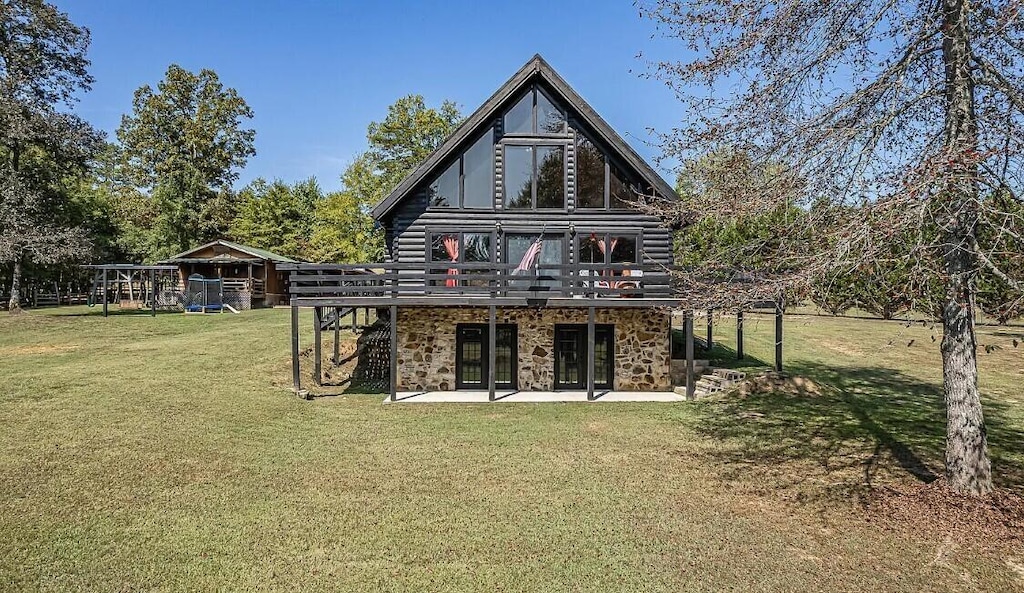 back of property with log siding, a deck, a yard, and a patio