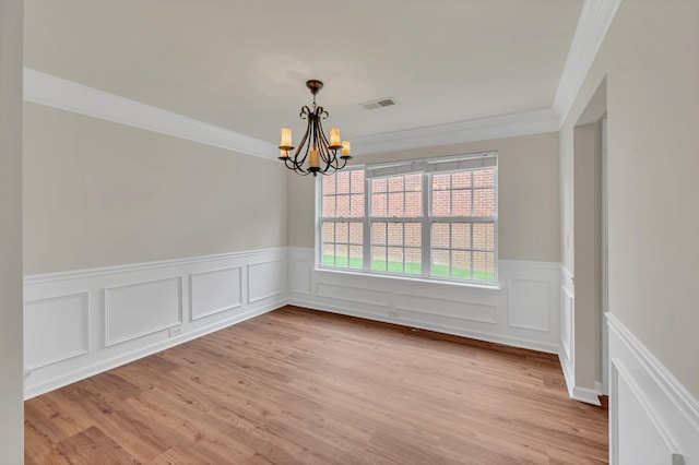 4725 Cape Hope Pass, Hermitage, TN 37076 - unfurnished dining area featuring a chandelier, crown molding, a wainscoted wall, light wood finished floors, and a decorative wall