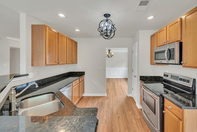 4725 Cape Hope Pass, Hermitage, TN 37076 - kitchen with stainless steel appliances, a sink, a chandelier, light wood-type flooring, and dark stone counters