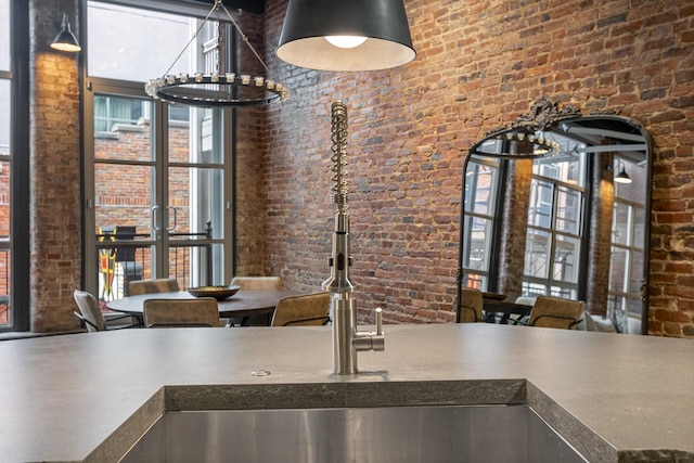 kitchen with brick wall, a towering ceiling, and healthy amount of natural light