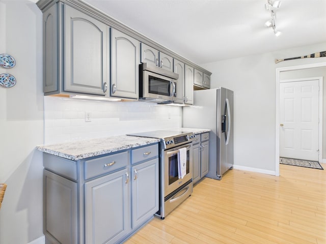 378 Roy Harris Rd, Kuttawa, KY 42055 - kitchen featuring appliances with stainless steel finishes, backsplash, light stone countertops, and gray cabinetry