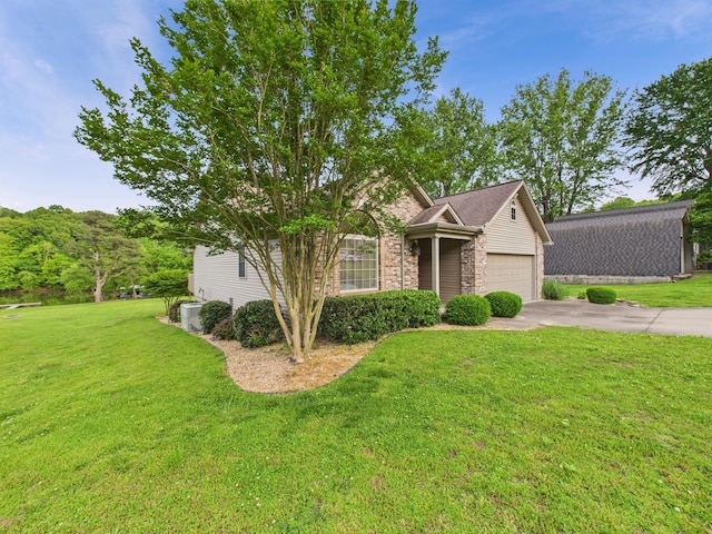 378 Roy Harris Rd, Kuttawa, KY 42055 - view of front facade featuring concrete driveway, a front lawn, an attached garage, cooling unit, and brick siding