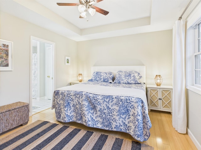 378 Roy Harris Rd, Kuttawa, KY 42055 - bedroom featuring baseboards, light wood finished floors, a ceiling fan, and a tray ceiling