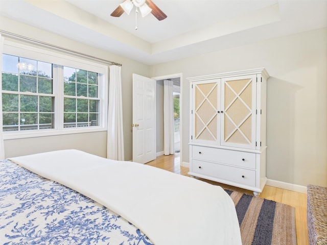 378 Roy Harris Rd, Kuttawa, KY 42055 - bedroom with light wood-style flooring, baseboards, a tray ceiling, and ceiling fan