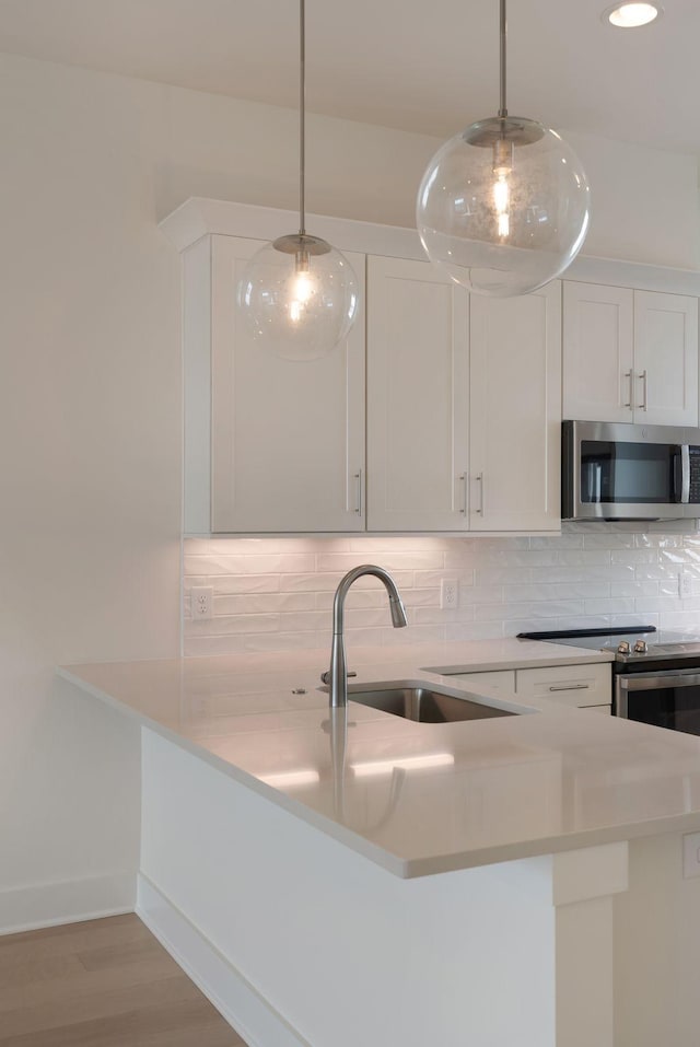 520 Proximity Cir, Nashville, TN 37207 - kitchen with appliances with stainless steel finishes, a sink, backsplash, light countertops, and white cabinetry
