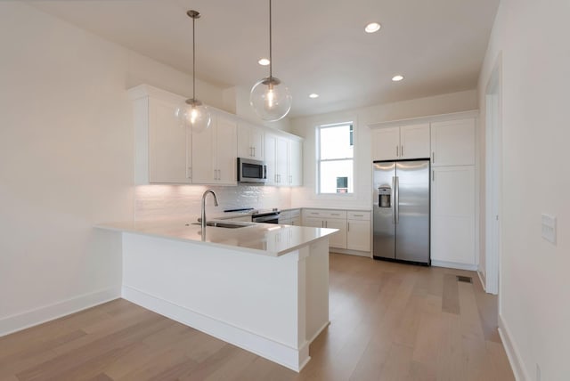 520 Proximity Cir, Nashville, TN 37207 - kitchen featuring appliances with stainless steel finishes, a sink, decorative backsplash, a peninsula, and light countertops