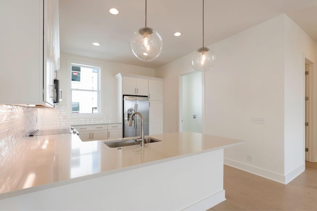 520 Proximity Cir, Nashville, TN 37207 - kitchen featuring appliances with stainless steel finishes, a peninsula, decorative backsplash, light wood-style flooring, and a sink