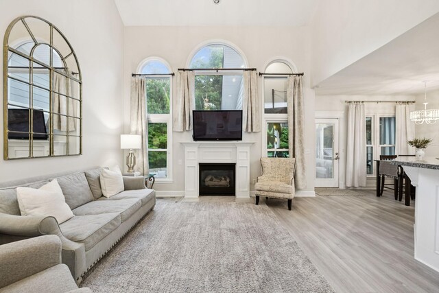 9455 Foothills Ct, Brentwood, TN 37027 - living area featuring wood finished floors, a chandelier, a fireplace with flush hearth, and a high ceiling
