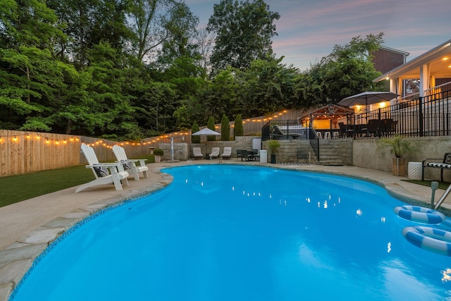 9455 Foothills Ct, Brentwood, TN 37027 - pool at dusk featuring a patio and a fenced backyard